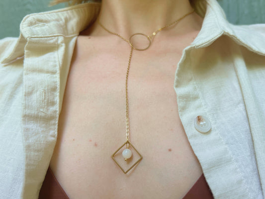 Gold lariat necklace with o ring featuring a moonstone in a square at the drop