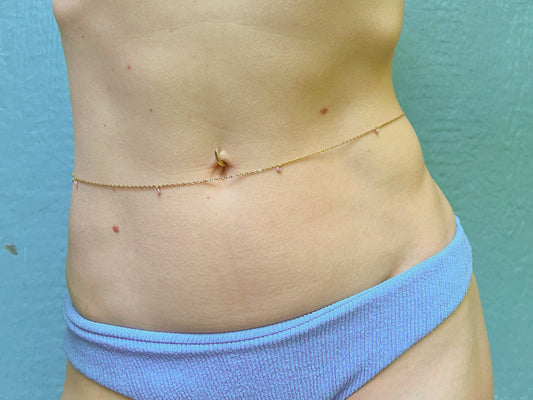 Person wearing a dainty beaded belly chain with tiny lavender beads