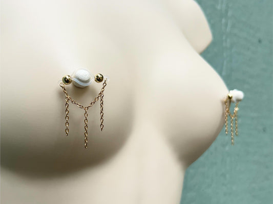 nipple jewelry for unpierced nipples with dainty gold chain, barbell nipple piercing with chains, fake nipple piercing with triple chain, nipple rings